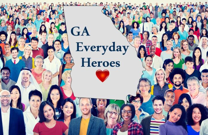 GA Everyday Heroes blue text on outline version of Georgia state map overlaid on very large group of racially diverse people standing close together