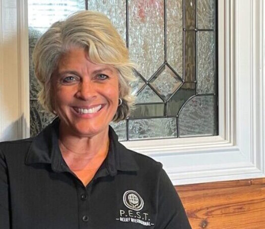 Everyday Hero: Andrea Hancock dreams of a night when bed bugs don’t bite GA Everyday Heroes: Headshot Andrea Hancock middle-aged woman with short silver hair in black shirt with P.E.S.T. round logo in white, in front of leaded glass window of red brick building