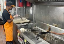Restaurant customers remain unhappy with high menu prices A cook in an orange apron stands over a large grill.