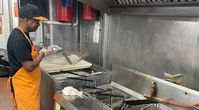 Restaurant customers remain unhappy with high menu prices A cook in an orange apron stands over a large grill.