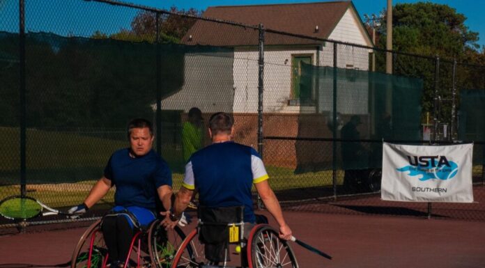 Heart and skill on display at USTA Wheelchair Tennis Championship Two men in wheelchairs dressed in athletic-wear holding tennis rackets high-five each other on a tennis court. There is a banner behind them that reads, "USTA, find yourself in the game, Southern."