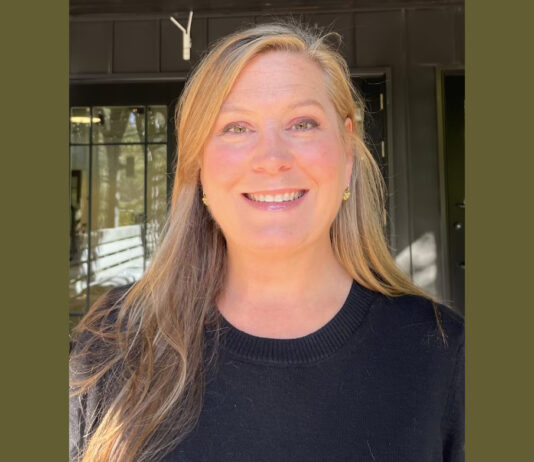 Everyday Hero: Animal lover’s nonprofit helps thousands of furry friends A profile photo of a blonde woman with long hair smiling at the camera. She is wearing a black sweater and small gold earrings. She is standing in front of a dark green building.
