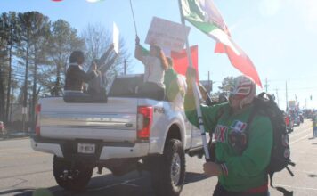 Protestors in Chamblee march against Trump’s deportation orders A protester dressed as a Wrestler running with the flag of Mexico. (Zaire Breedlove/ Fresh Take Georgia)