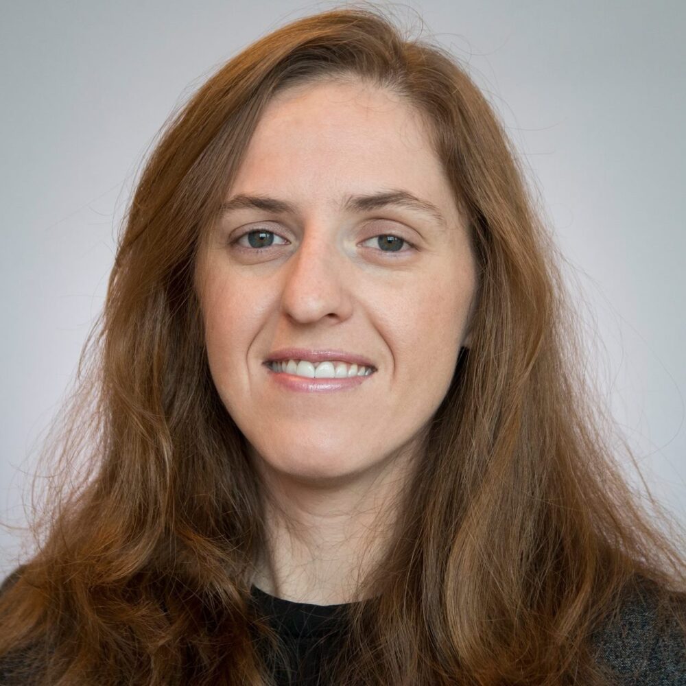 Headshot Elaine Venter: woman with long brown hair in black top.